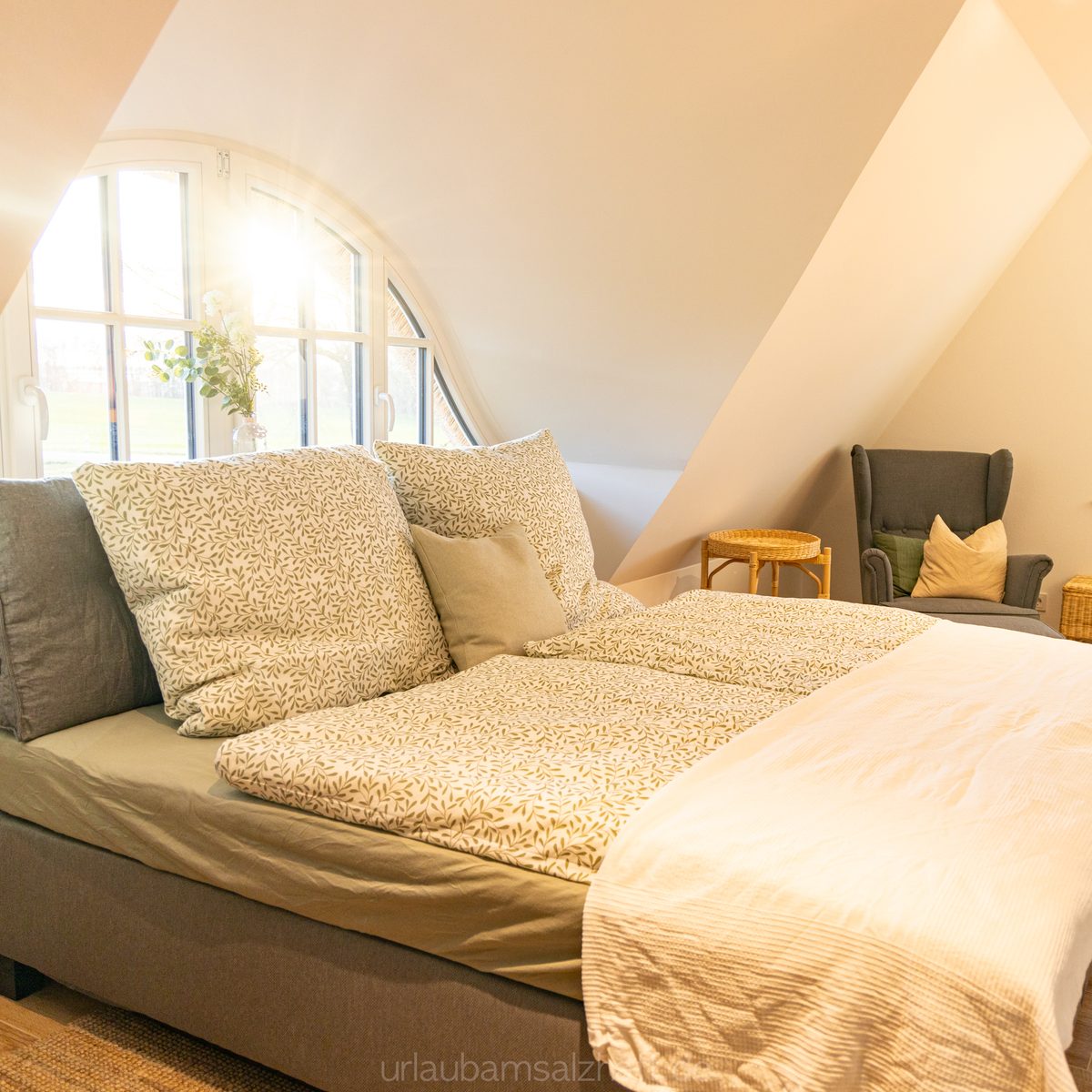 Weites, einladendes Doppelbett in einem lichtdurchfluteten Schlafzimmer mit stilvoller Sitzgele