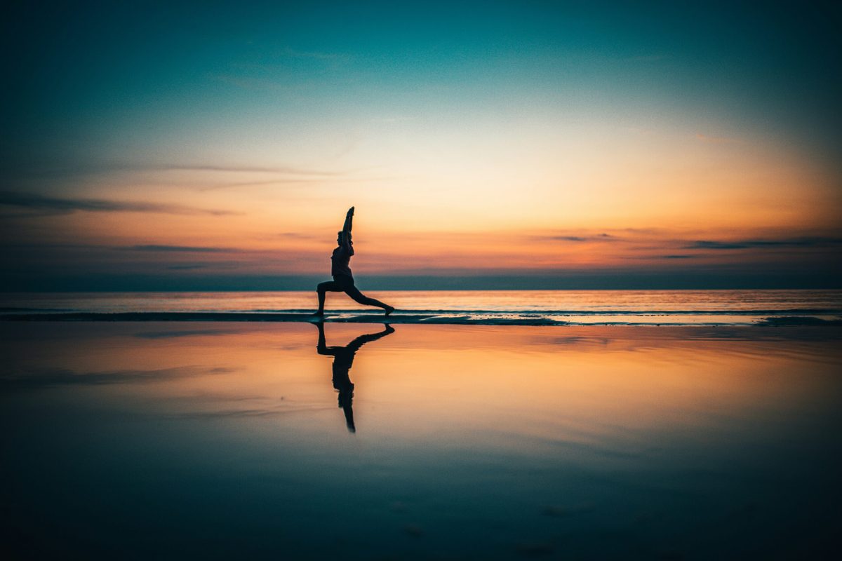 Yoga am Strand bei Sonnenuntergang.
