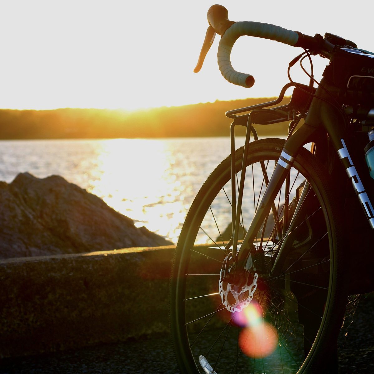 Fahrrad im Vordergrund mit Sonnenuntergang über der Ostsee im Hintergrund