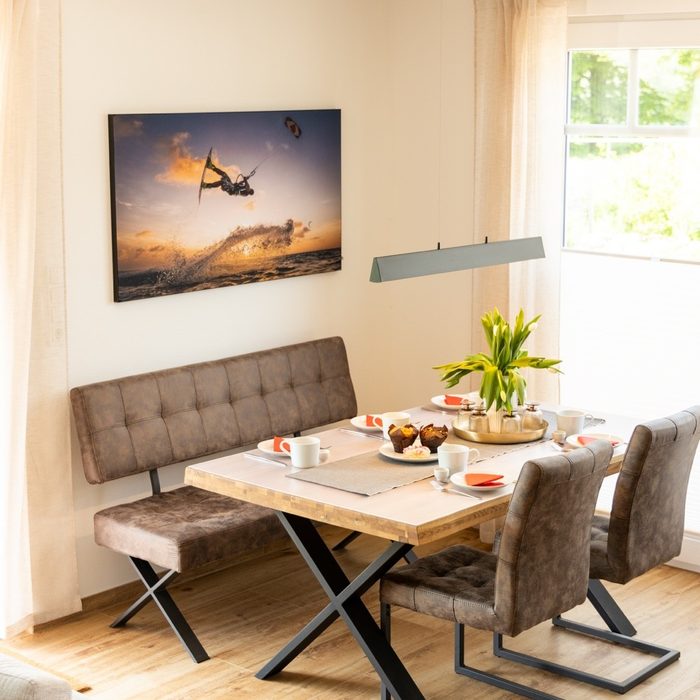 Essbereich im Ferienhaus Pepelow mit gedecktem Tisch und großem Fenster