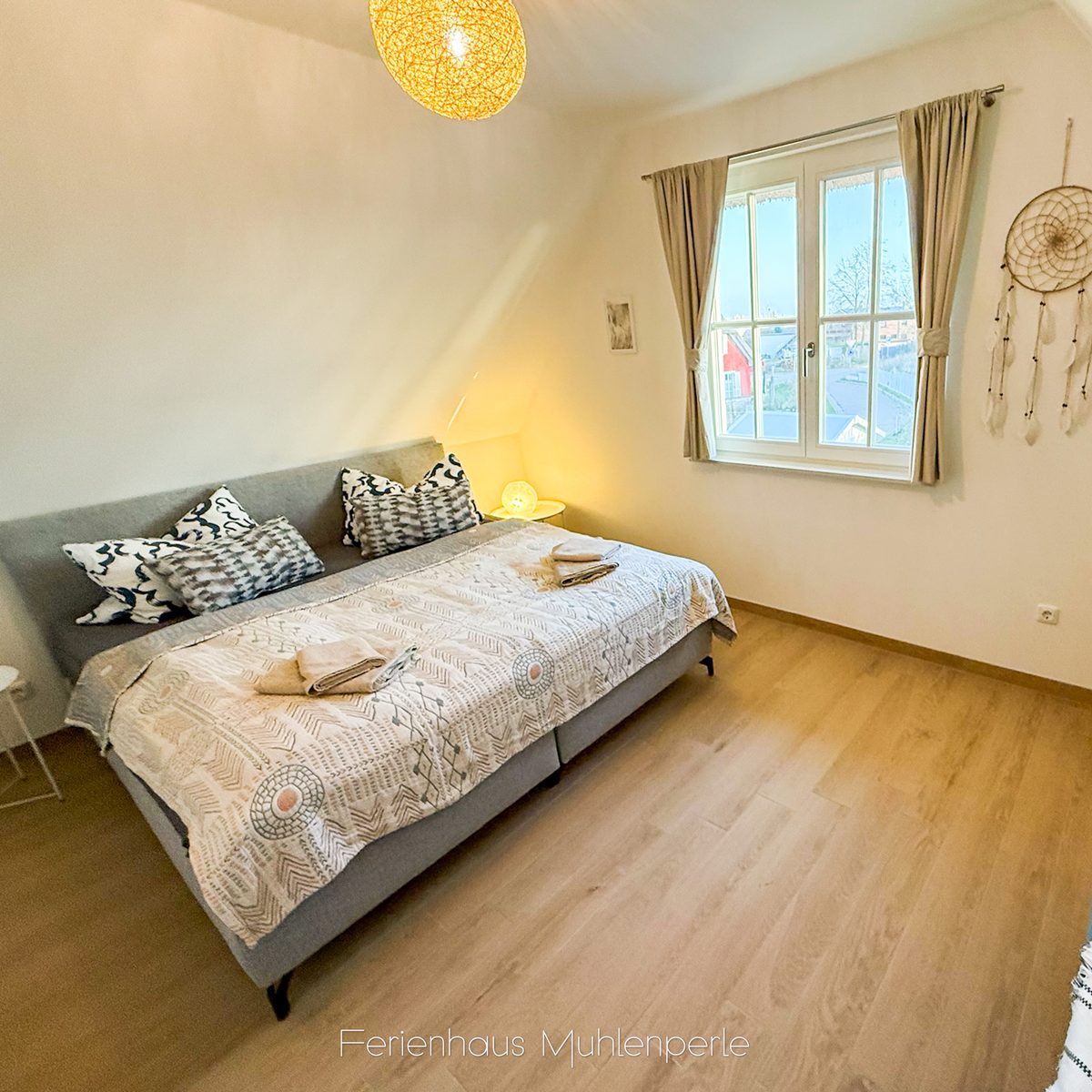 Gemütliches Schlafzimmer mit Queensize-Boxspringbett und warmem Tageslicht im Ferienhaus Mühlen