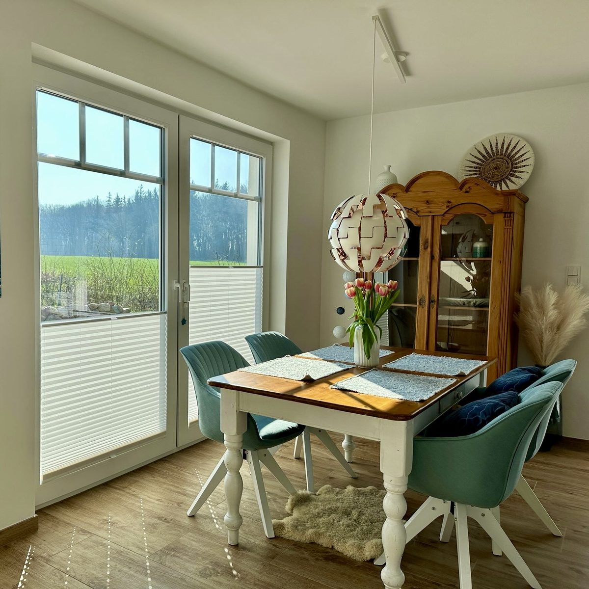 Helle Essecke mit Landhausstil-Möbeln und einem Fenster mit Blick ins Grüne.