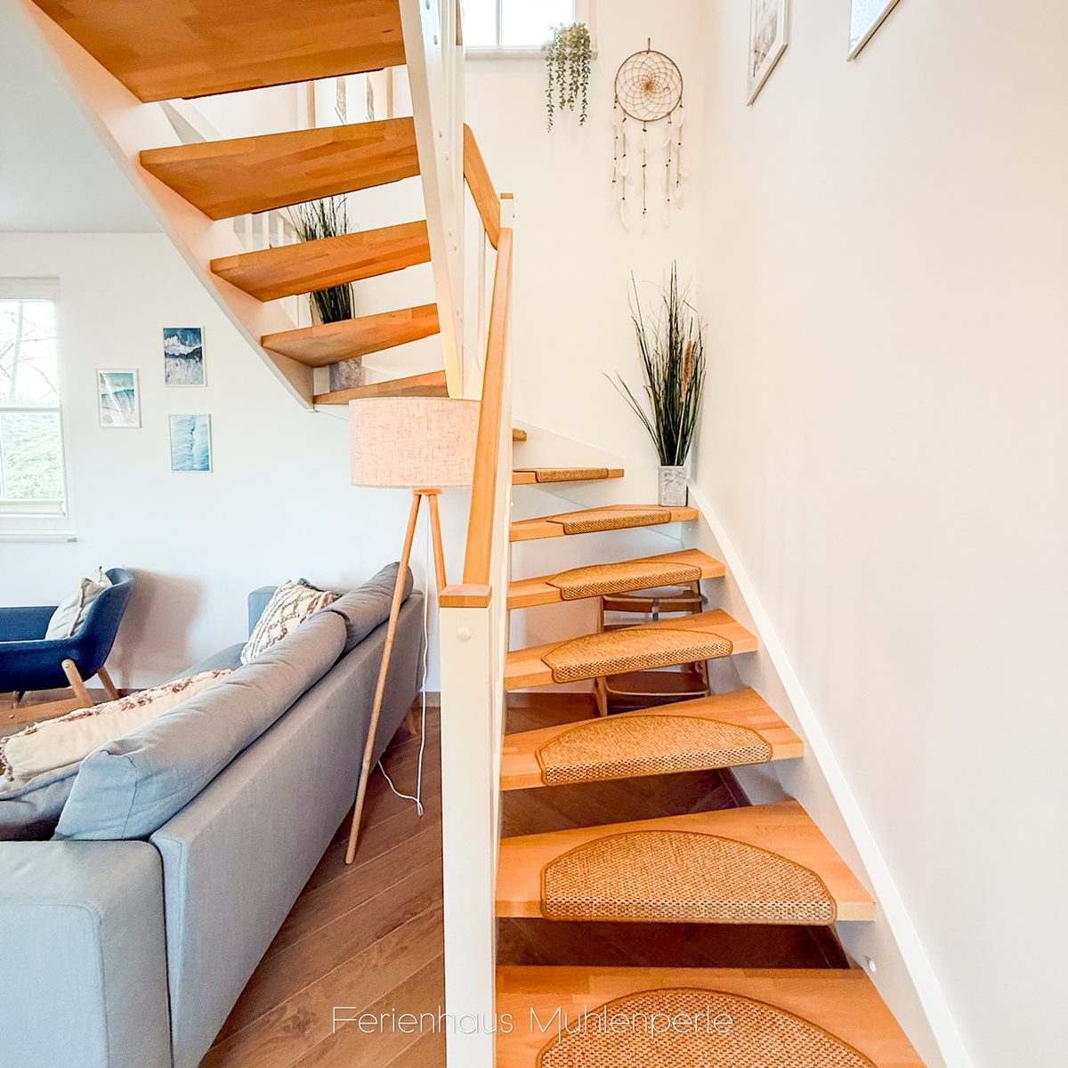 Holztreppe mit dekorativen Details und modernen Akzenten im Ferienhaus Mühlenperle.