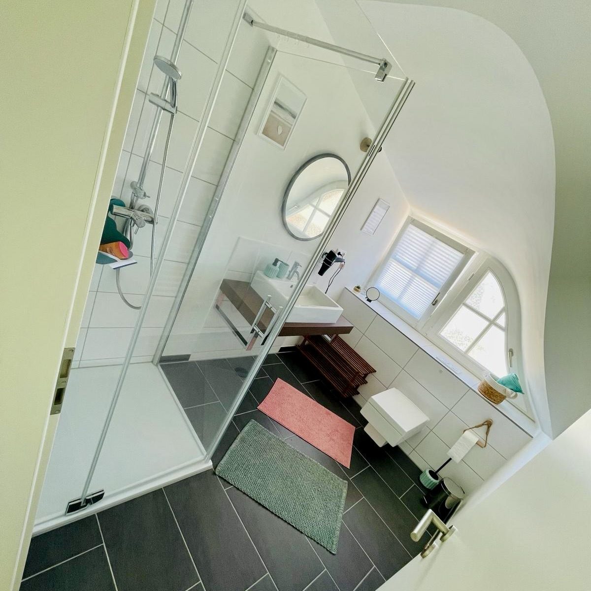Helles, geräumiges Badezimmer mit großer Dusche und modernen Einrichtungsdetails.
