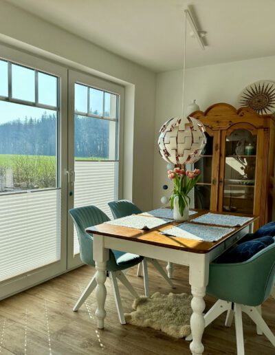 Helle Essecke mit Landhausstil-Möbeln und einem Fenster mit Blick ins Grüne.