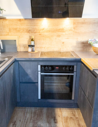 Hochwertig ausgestattete Küche mit modernen Geräten und warmen Holzelementen.